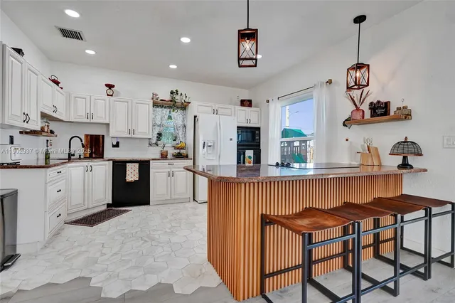 a kitchen with stainless steel appliances granite countertop a sink and a refrigerator