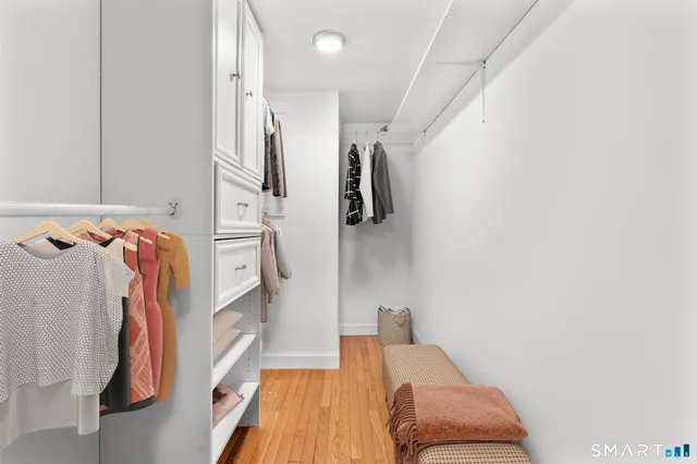 a view of walk in closet with clothes and shoes