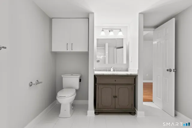 a bathroom with a toilet sink and mirror