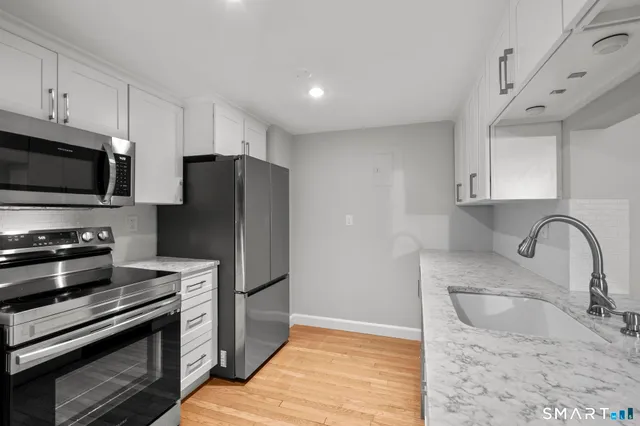 a kitchen with stainless steel appliances granite countertop a refrigerator and a sink