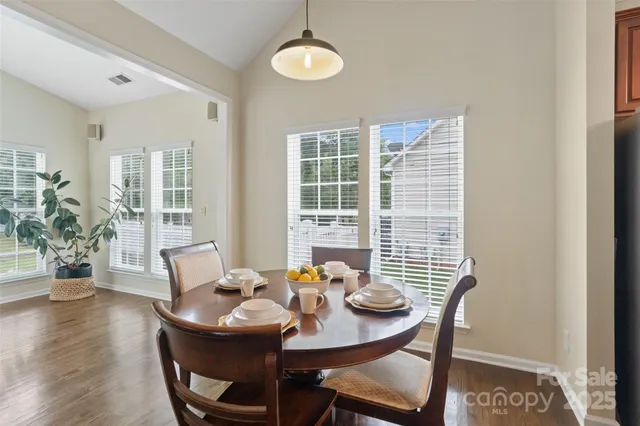 a living room with furniture floor to ceiling window and wooden floor