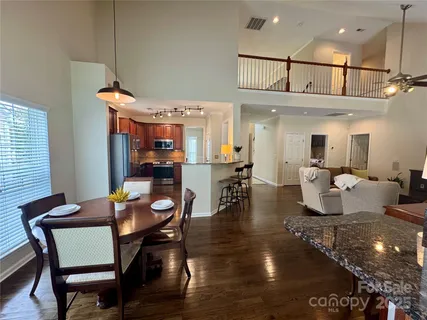 a dining room with furniture a rug and kitchen view