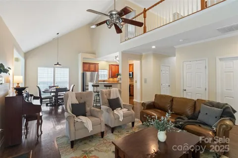 a living room with furniture kitchen view and a chandelier
