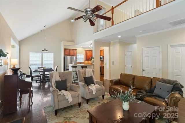 a living room with furniture kitchen view and a chandelier