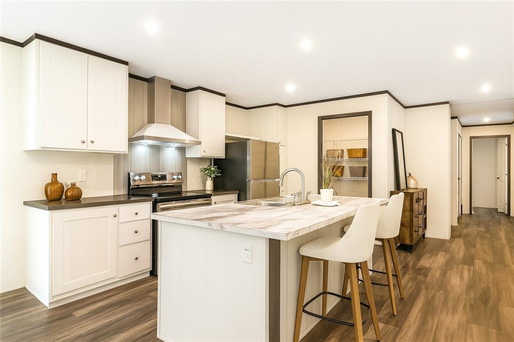 152 Wendy Hill Road Ellijay, GA 30536 - Photo 12 of 42 a kitchen with stainless steel appliances a table chairs and a refrigerator