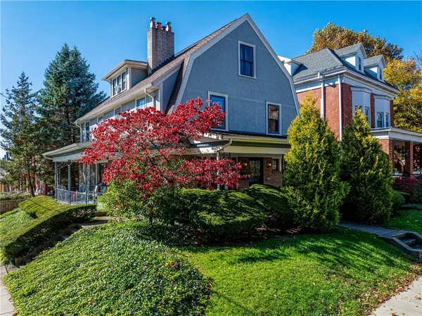 a front view of house and yard with beautiful flowers and green space