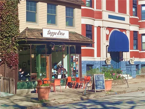 a front view of multi story building with retail shops