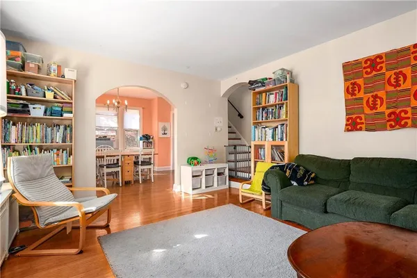 a living room with furniture a bookshelf and a large window