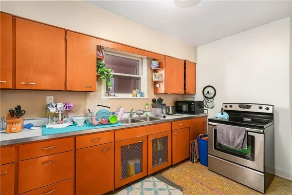 a kitchen with stainless steel appliances granite countertop a stove a sink and a microwave