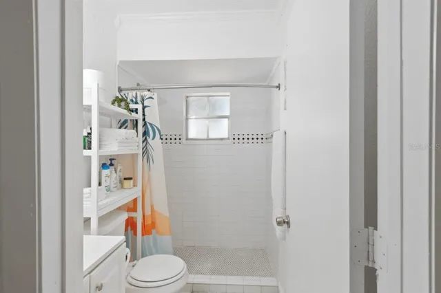 a bathroom with a toilet and a shower curtain
