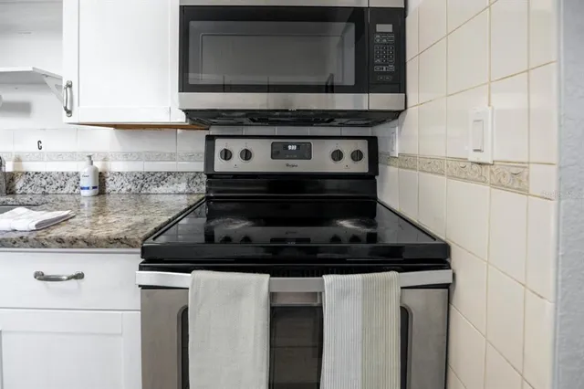 a kitchen with stainless steel appliances granite countertop a stove and a microwave