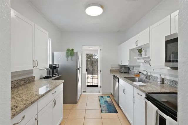 a kitchen with granite countertop a sink stove and cabinets