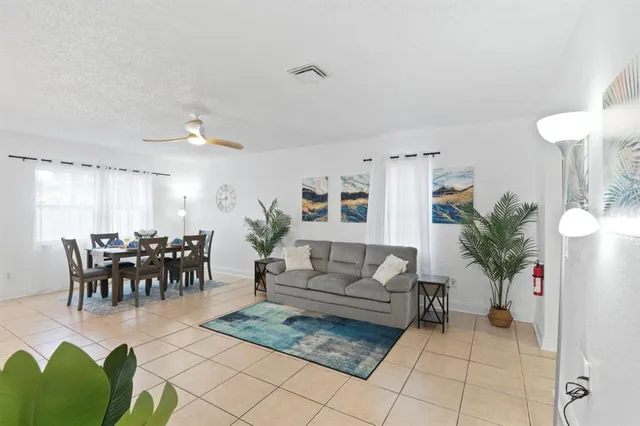a living room with furniture potted plant and a table