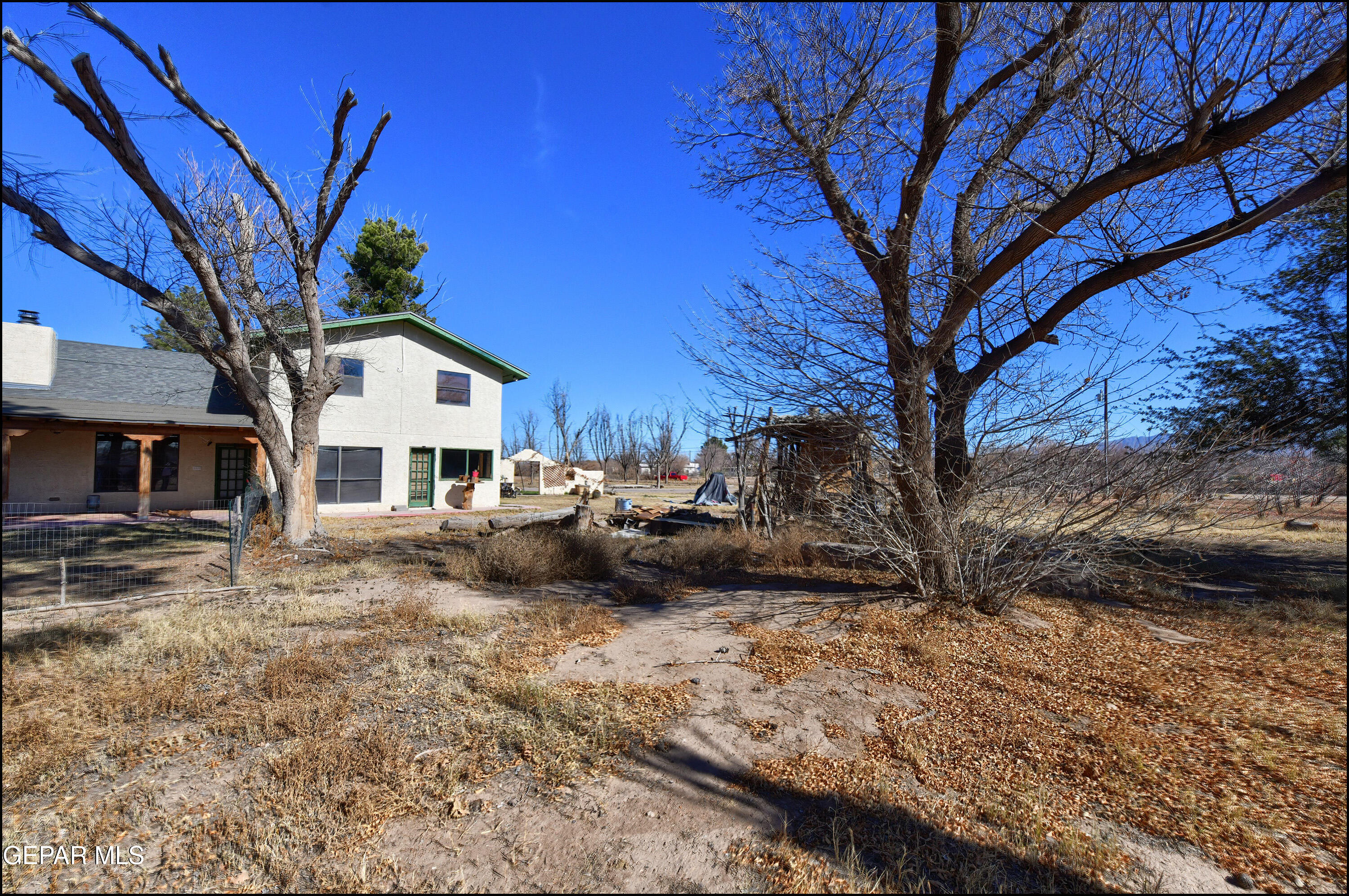 395 Gabaldon Road Anthony, NM 88021 - Photo 50 of 84 a view of a white house and a yard with a large tree