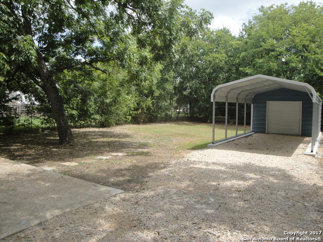 615 East Elm Street Seguin, TX 78155 - Photo 21 of 23 a backyard of a house with a barbeque oven and tree