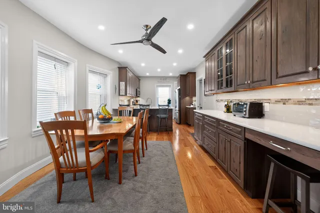 a kitchen with stainless steel appliances kitchen island granite countertop a sink a stove a dining table and chairs