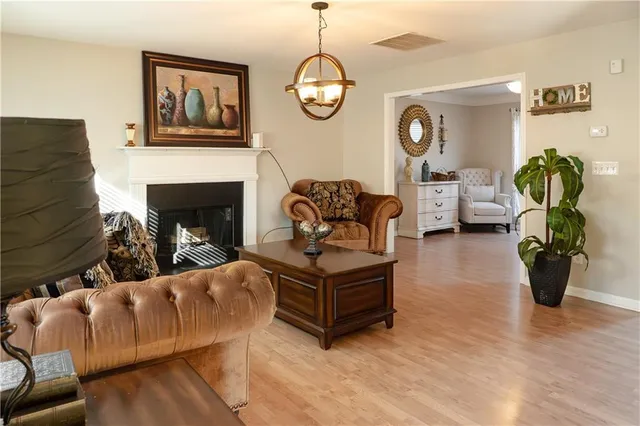 a living room with furniture a chandelier and a fireplace