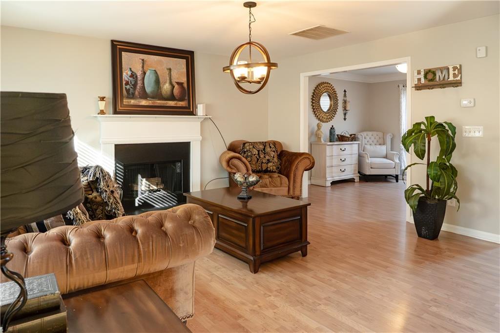 1004 Cavesson Terrace Lawrenceville, GA 30045 - Photo 12 of 48 a living room with furniture a chandelier and a fireplace