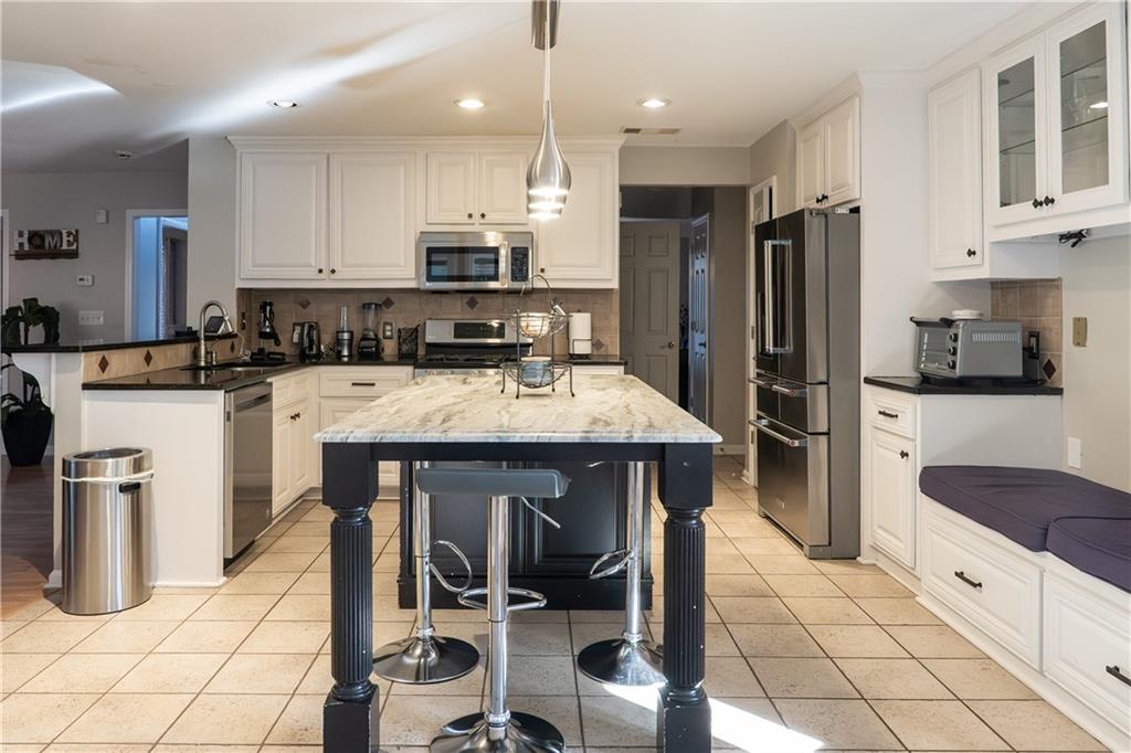 1004 Cavesson Terrace Lawrenceville, GA 30045 - Photo 14 of 48 a kitchen with granite countertop a stove a sink and a refrigerator