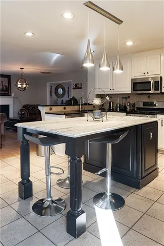 a kitchen with stainless steel appliances kitchen island granite countertop a sink a stove and a cabinets