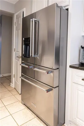 a metallic refrigerator freezer and a stove sitting inside of a kitchen