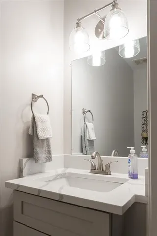 a bathroom with a sink vanity and a mirror
