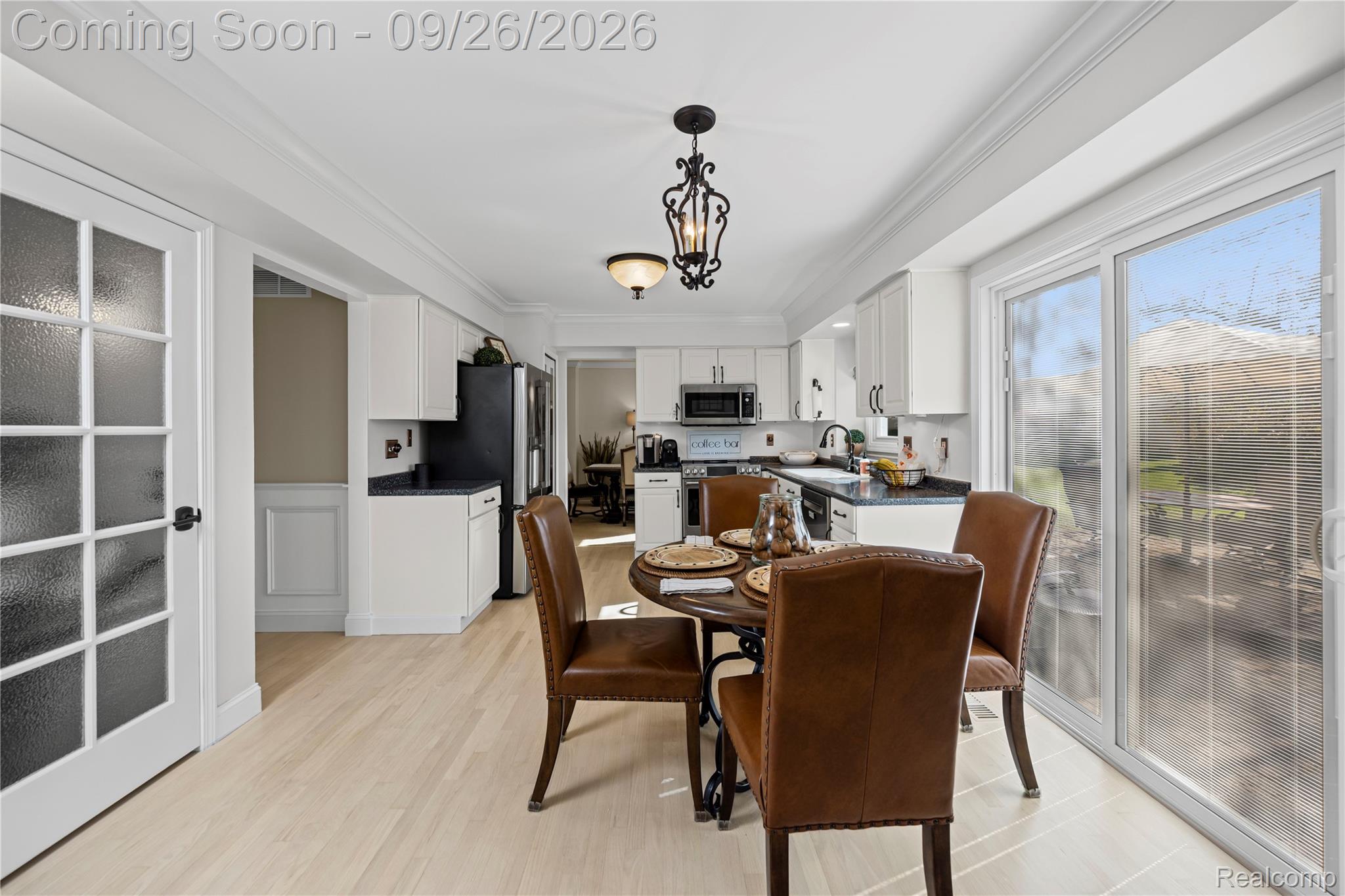 7021 Fox Path Canton, MI 48187 - Photo 22 of 59 Wood-finish flooring, white cabinetry, dark countertops, and a sliding glass door to the exterior
