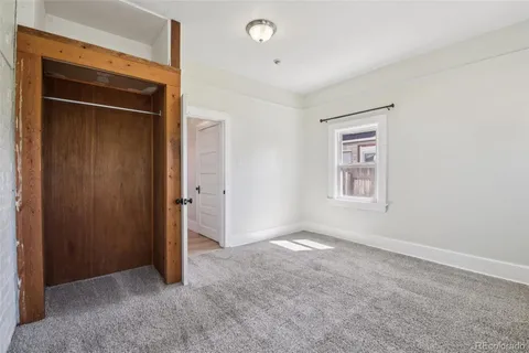 an empty room with windows and closet
