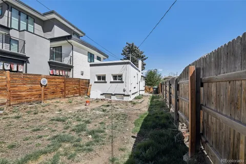 a view of a yard with plants and wooden fence