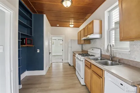 a kitchen with stainless steel appliances granite countertop a sink a stove and a refrigerator