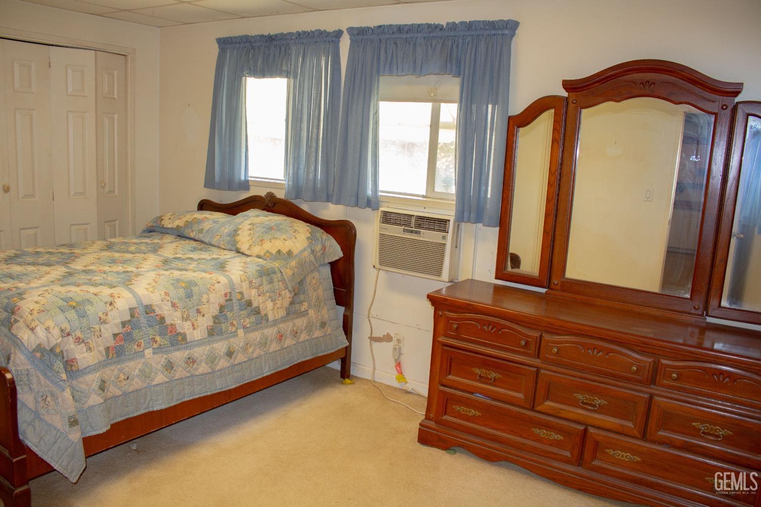 Undisclosed Address Bakersfield, CA 93307 - Photo 11 of 29 a bedroom with a bed and a mirror on dresser
