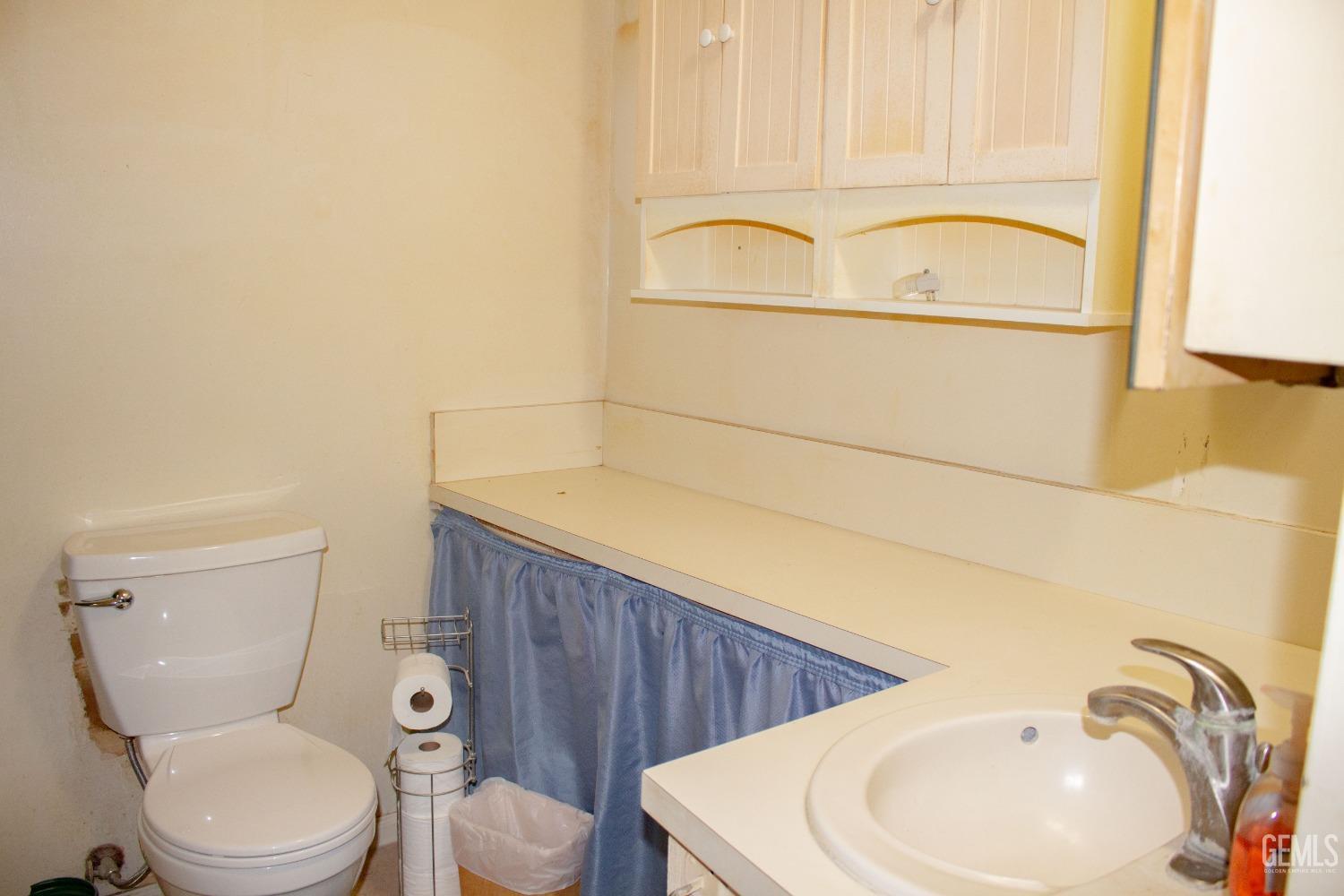 Undisclosed Address Bakersfield, CA 93307 - Photo 12 of 29 a white toilet sitting next to a bathroom sink