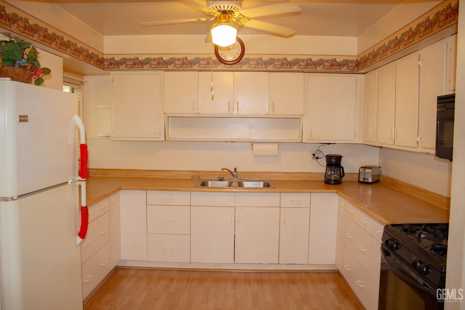 Undisclosed Address Bakersfield, CA 93307 - Photo 15 of 29 a kitchen with a sink cabinets and appliances