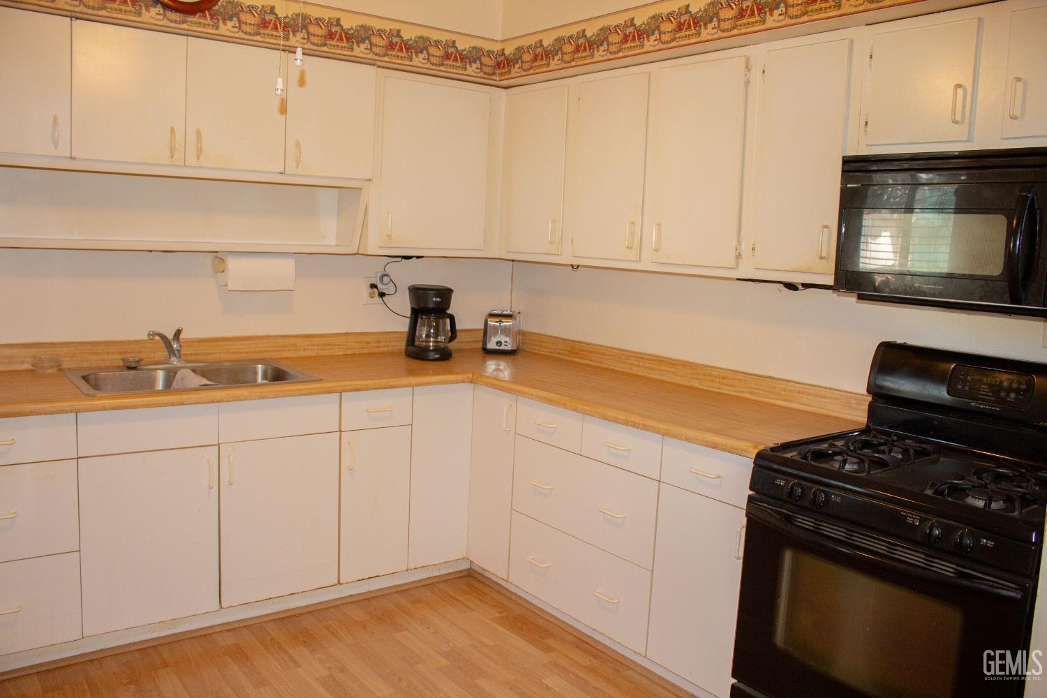 Undisclosed Address Bakersfield, CA 93307 - Photo 17 of 29 a kitchen with a sink and cabinets