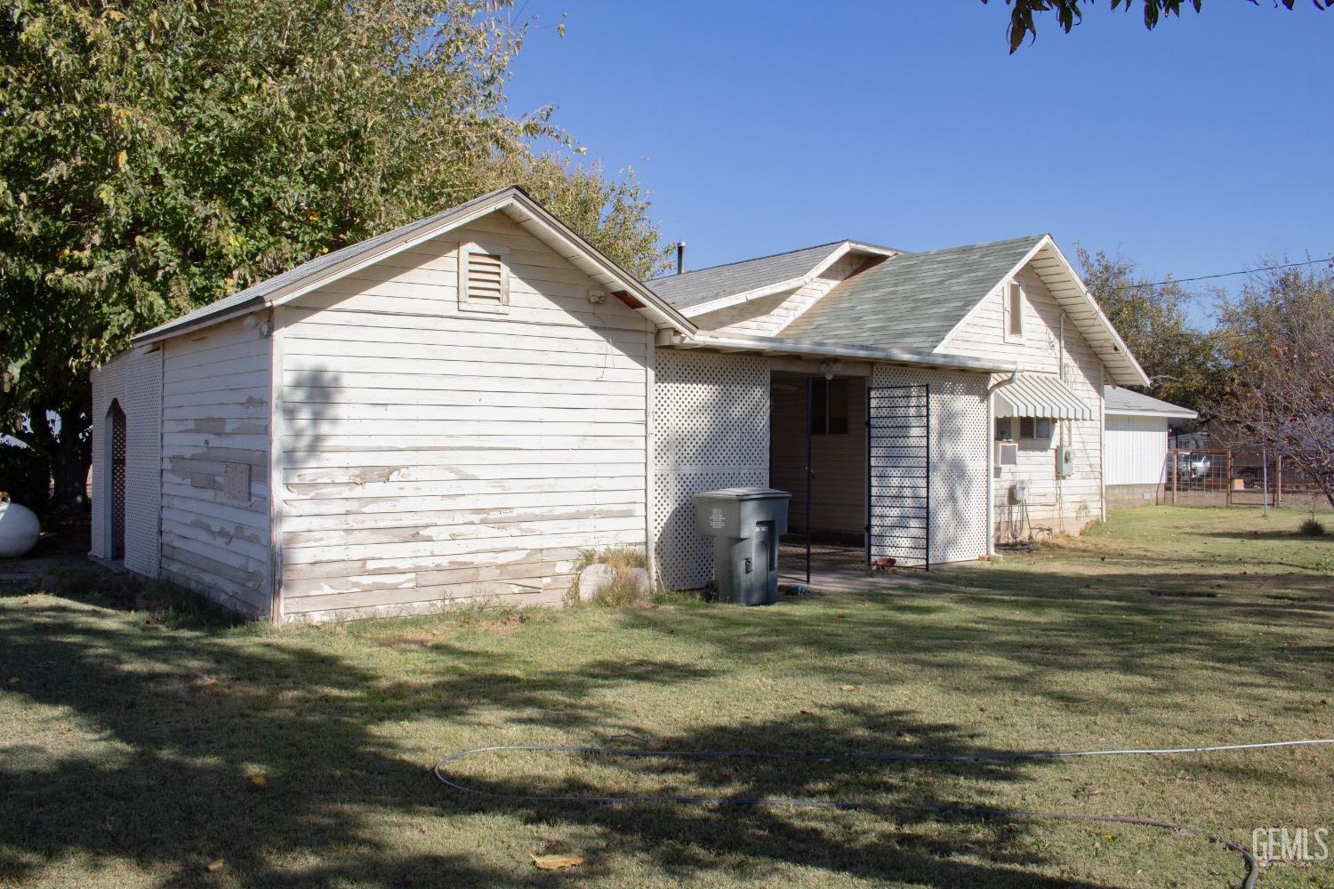 Undisclosed Address Bakersfield, CA 93307 - Photo 21 of 29 a front view of a house with a yard