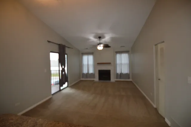 a view of an empty room with a fireplace and a window