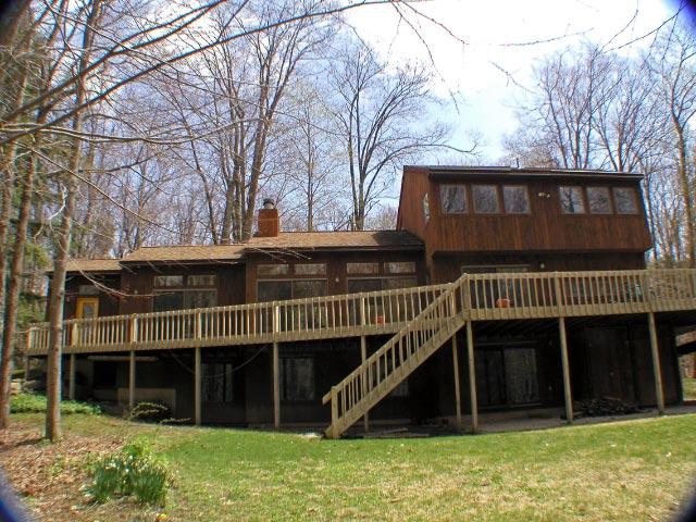 a view of a house with a large window and wooden fence