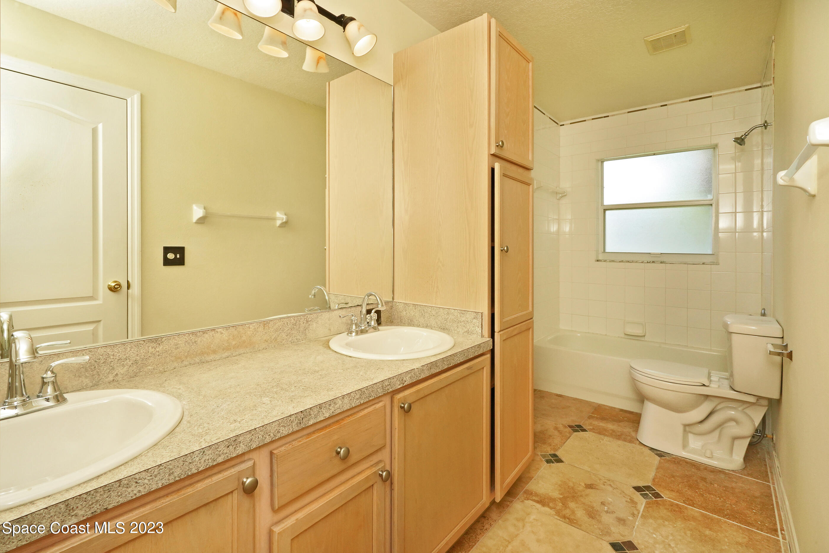 395 Brookcrest Circle Rockledge, FL 32955 - Photo 25 of 44 a bathroom with a granite countertop sink mirror vanity and toilet