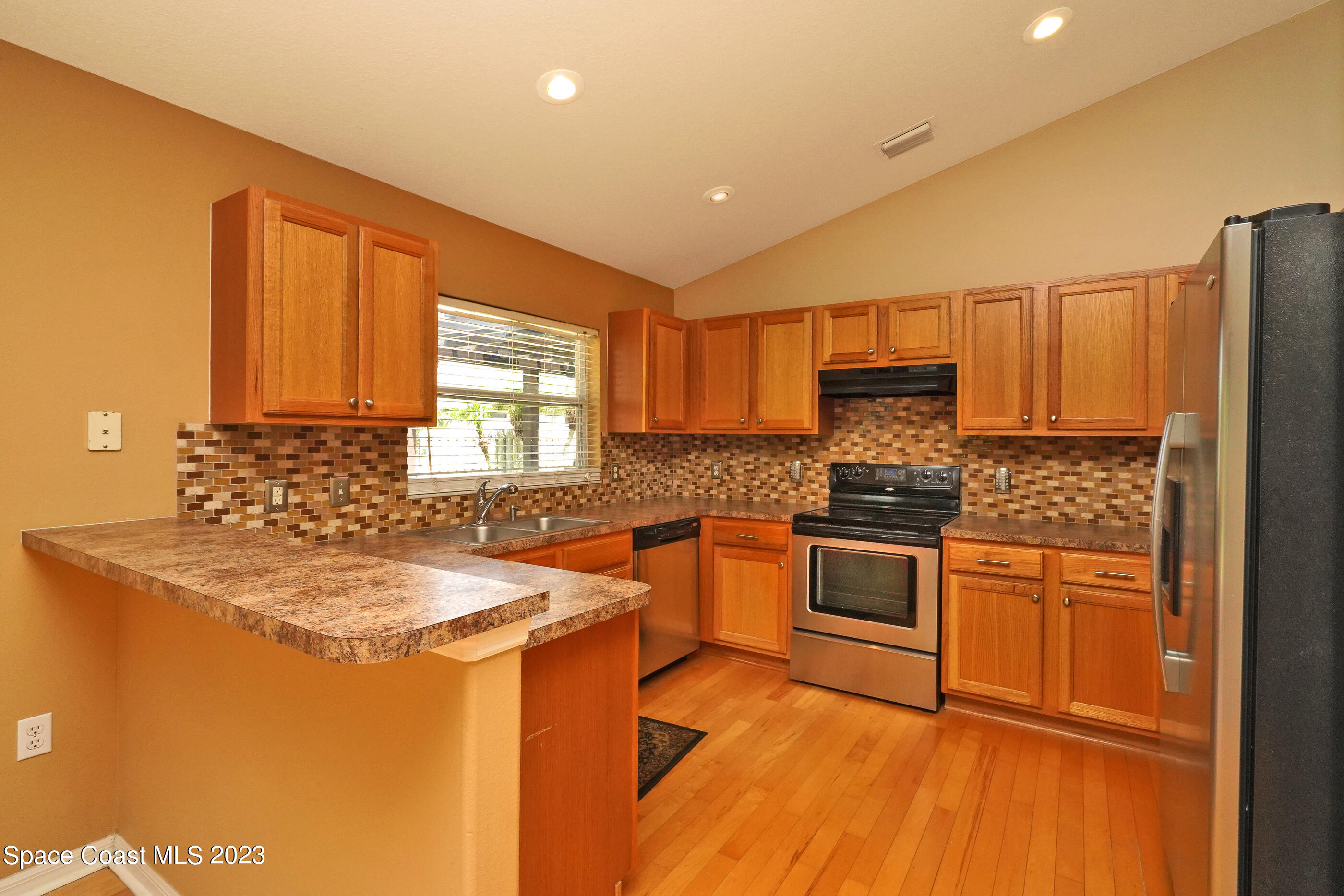395 Brookcrest Circle Rockledge, FL 32955 - Photo 29 of 44 a kitchen with stainless steel appliances granite countertop a sink stove and refrigerator