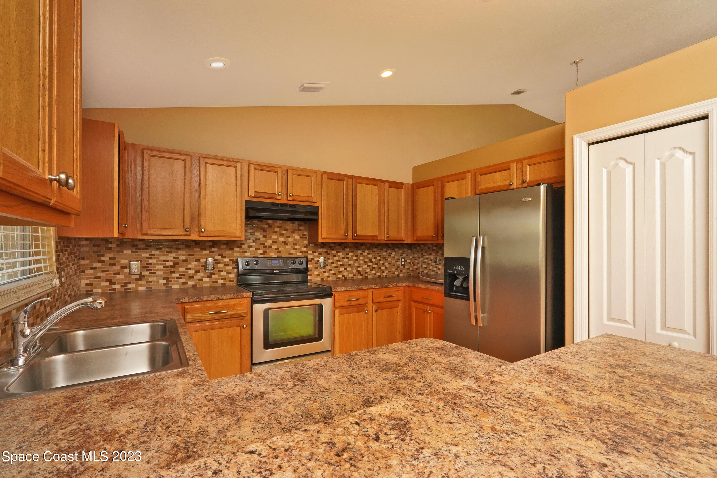 395 Brookcrest Circle Rockledge, FL 32955 - Photo 30 of 44 a kitchen with stainless steel appliances granite countertop a refrigerator sink and stove