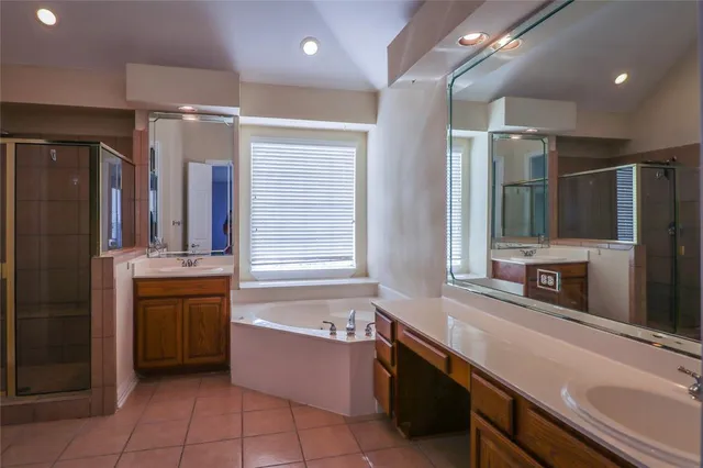 a bathroom with a bath tub a sink and a large mirror