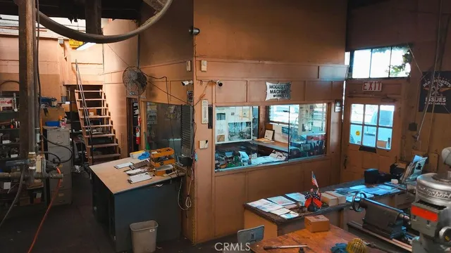 a view of a dining room with furniture a chandelier and window