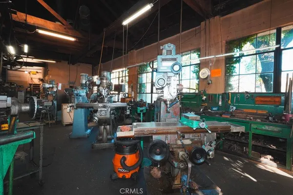 a view of a patio with table and chairs potted plants and a building