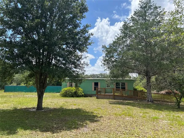 a view of a house with swimming pool and a yard