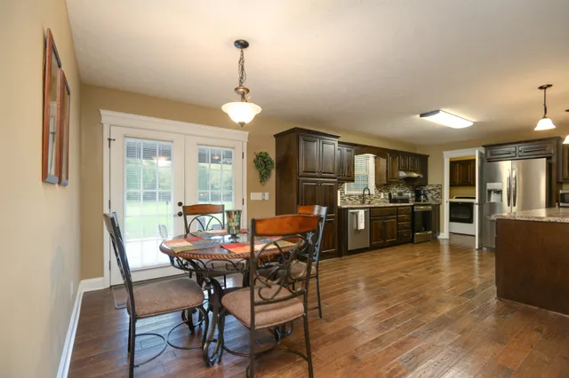 a dining room with furniture a chandelier and wooden floor
