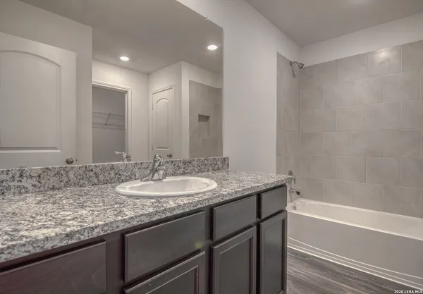 a bathroom with a granite countertop sink and a mirror