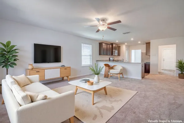 a living room with furniture a dining table and a potted plant