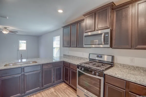 a kitchen with cabinets stove top oven and sink