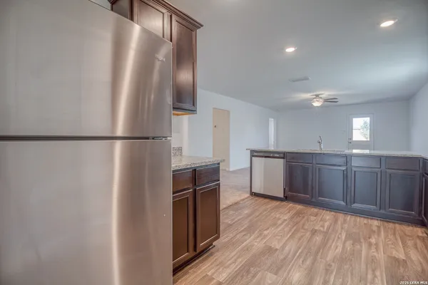 a kitchen with stainless steel appliances a refrigerator and wooden cabinets