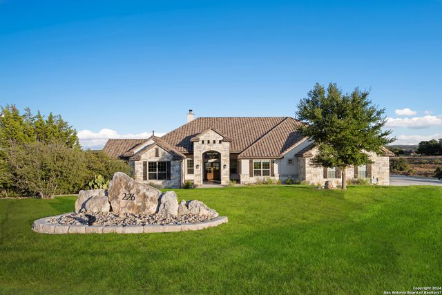 a front view of a house with a garden and trees